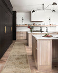 Beige and tan distressed floral pattern rug on dark wood flooring