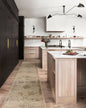 Beige and tan distressed floral pattern rug on dark wood flooring