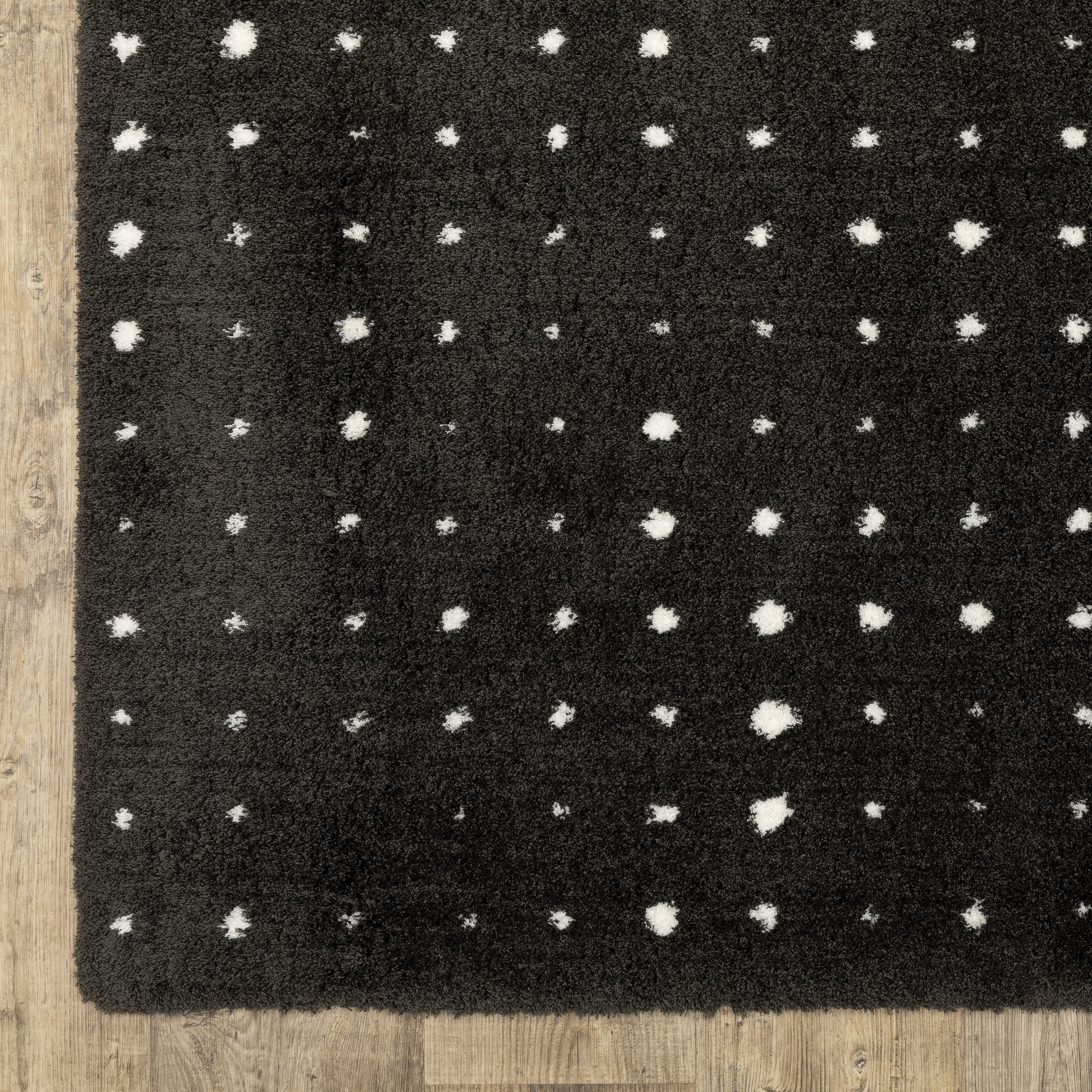 Black wool rug with white polka dot pattern and textured pile surface