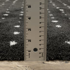 Black wool rug with white polka dot pattern and textured pile surface