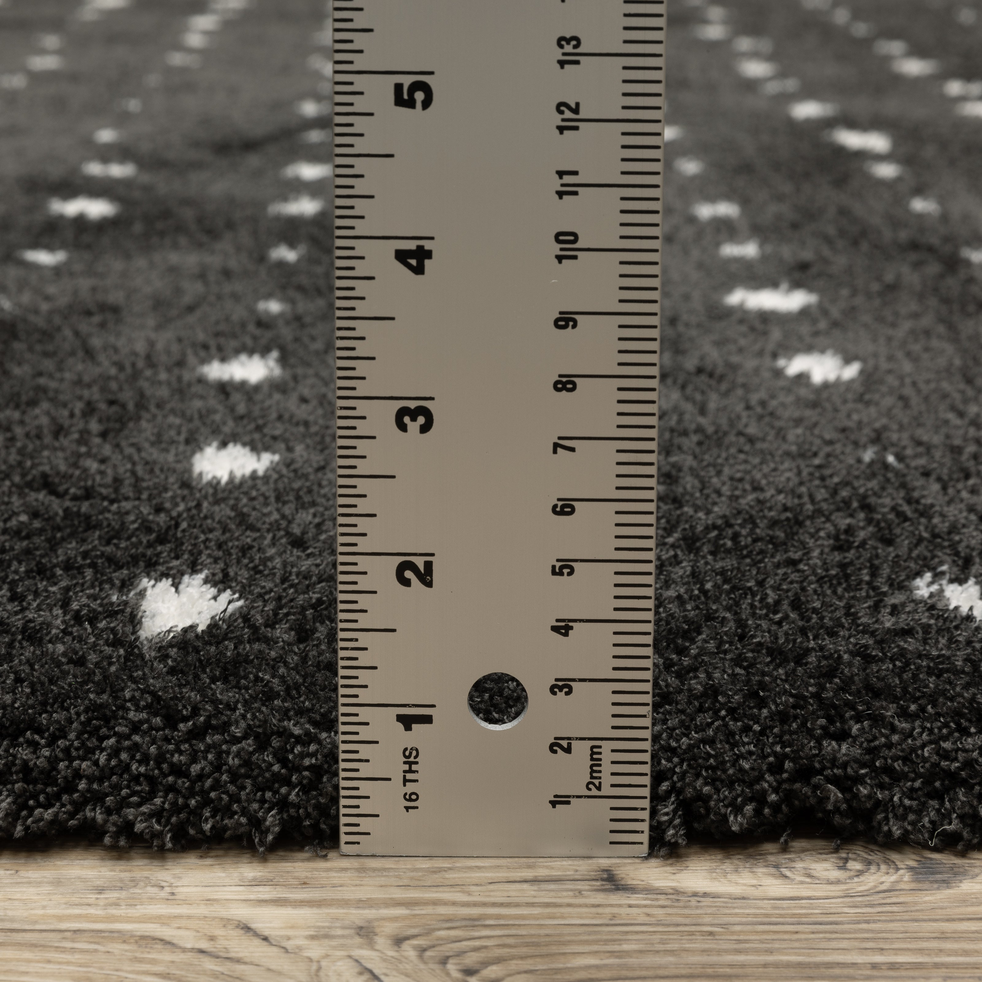Black wool rug with white polka dot pattern and textured pile surface