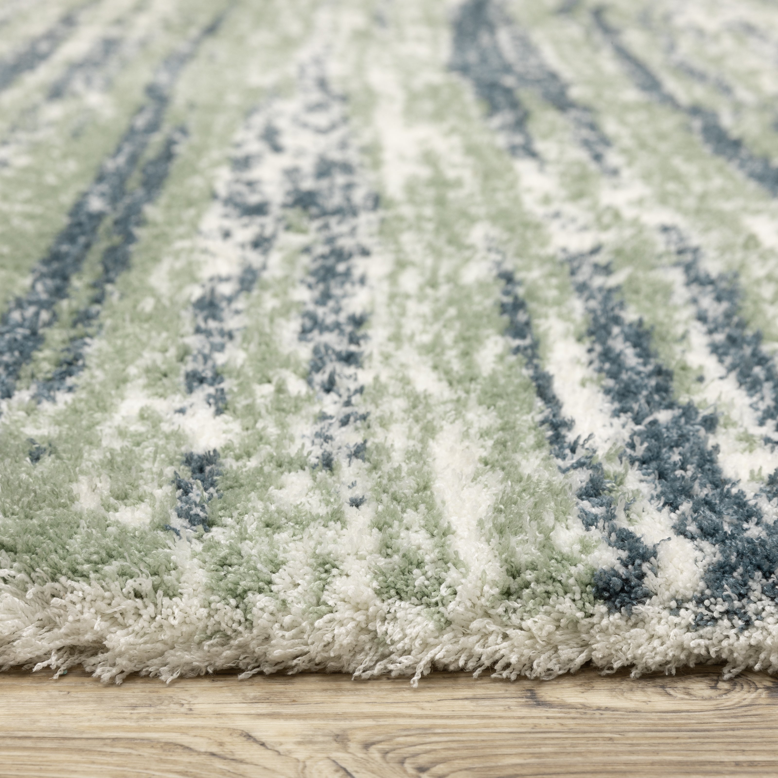 Striped area rug with green, navy and cream horizontal bands in textured weave