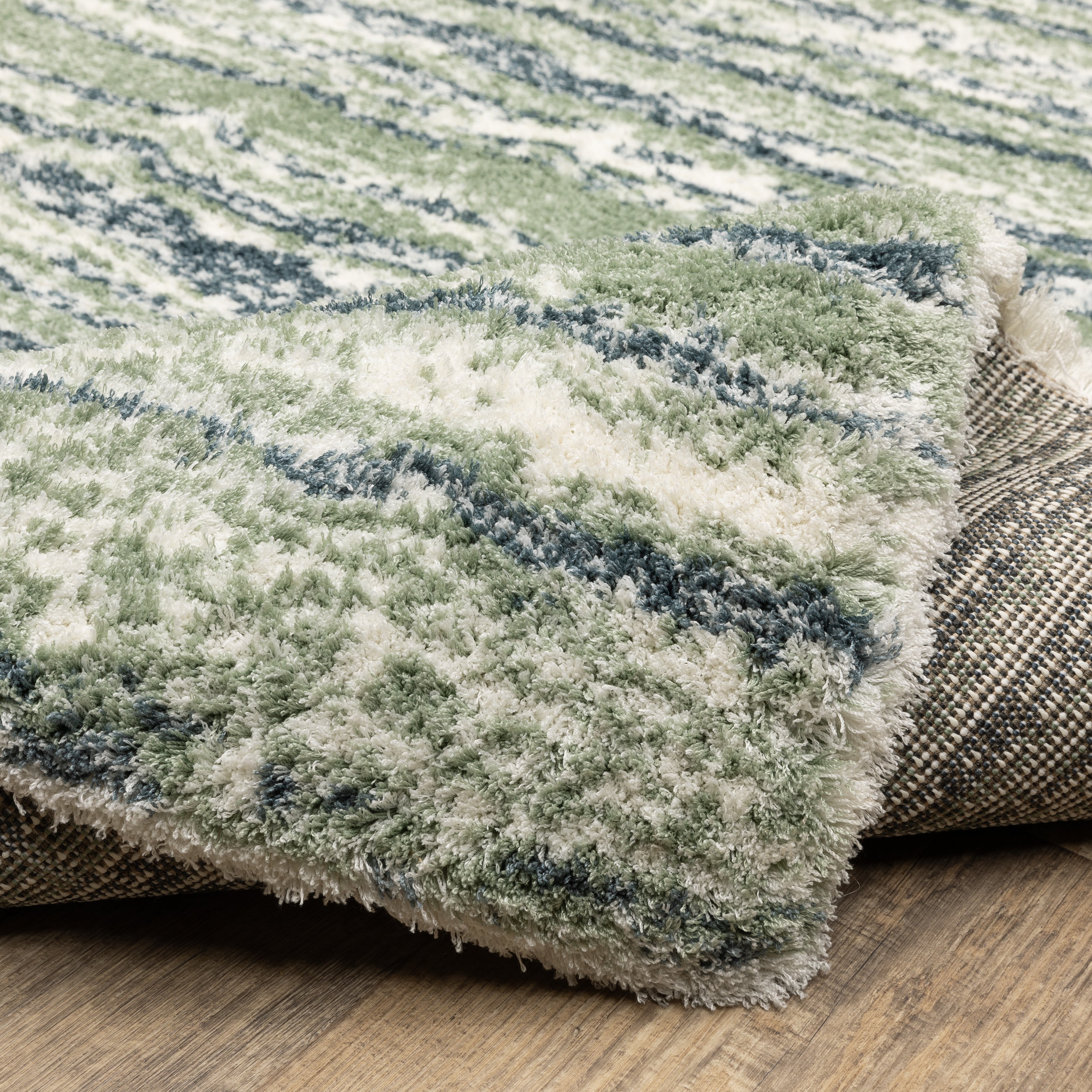 Striped area rug with green, navy and cream horizontal bands in textured weave