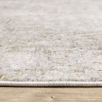 Distressed beige and tan vintage-style area rug with faded ornamental pattern