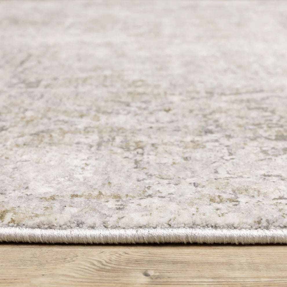 Distressed beige and tan vintage-style area rug with faded ornamental pattern