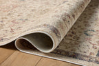 Vintage-style area rug with cream base, intricate geometric and floral patterns in rust and blue tones