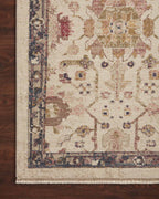Vintage-style area rug with cream base, intricate geometric and floral patterns in rust and blue tones