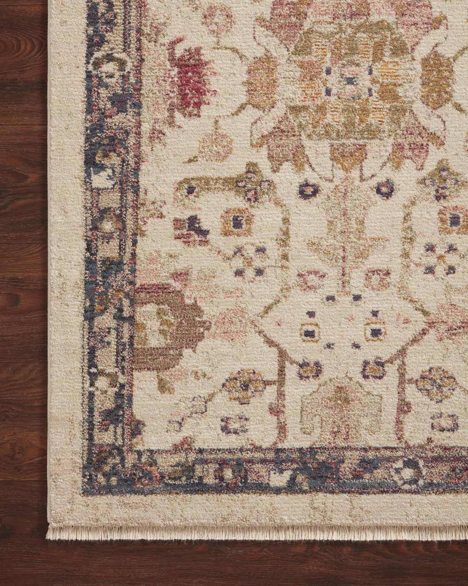 Vintage-style area rug with cream base, intricate geometric and floral patterns in rust and blue tones