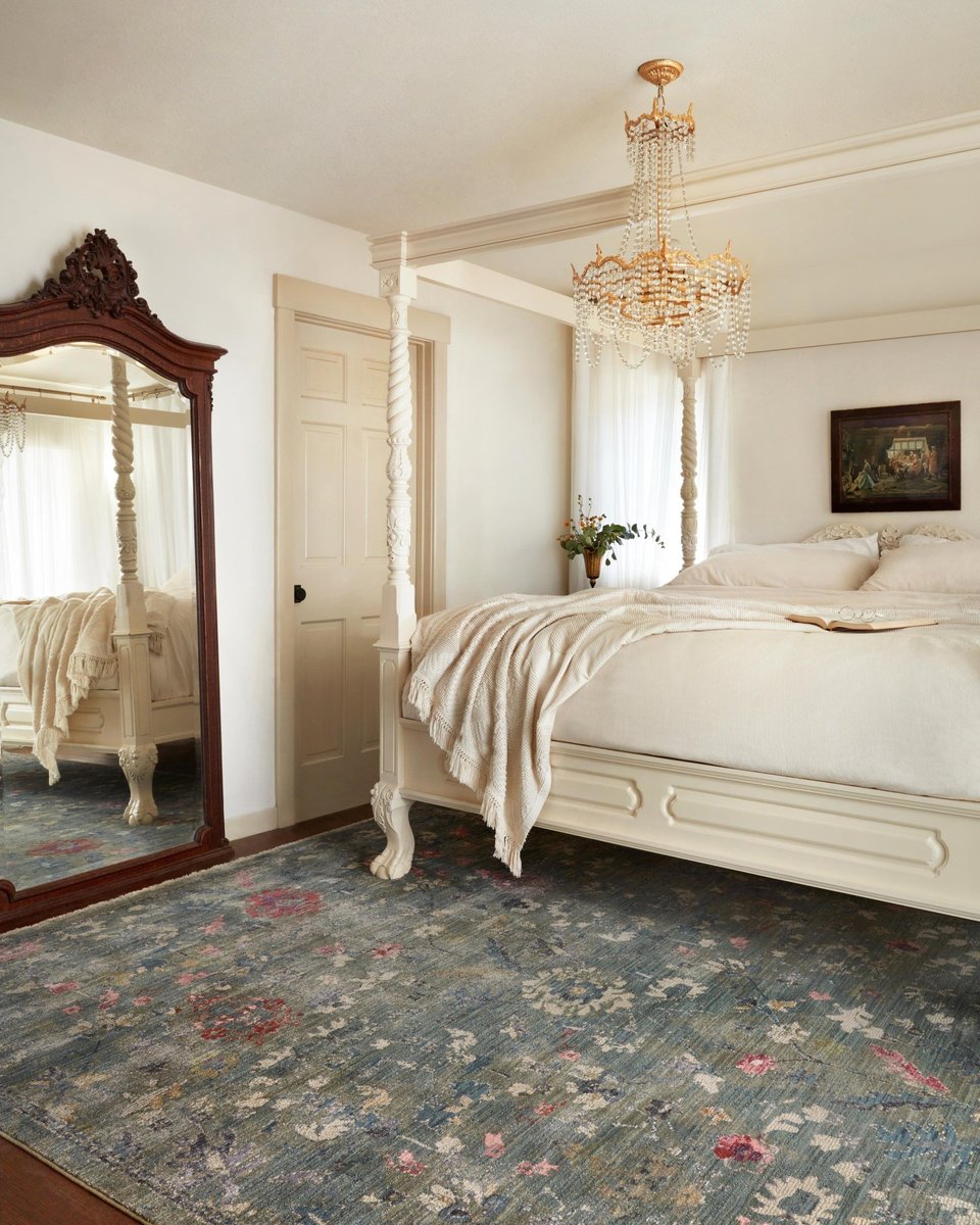 Vintage-style rug with blue-gray base and faded floral pattern in cream and red tones