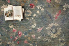 Vintage-style rug with blue-gray base and faded floral pattern in cream and red tones